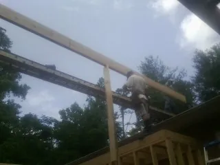 Carpenter setting a ridge beam over a new addition frame — Ice Dam Removal by Roofing Brothers in Rifle