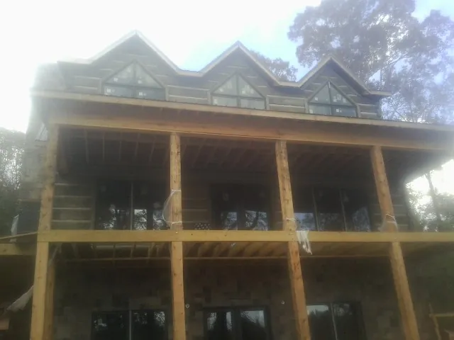 Dormers and porch framing on a large log home under construction — Roof Coating work by our crew in Rifle